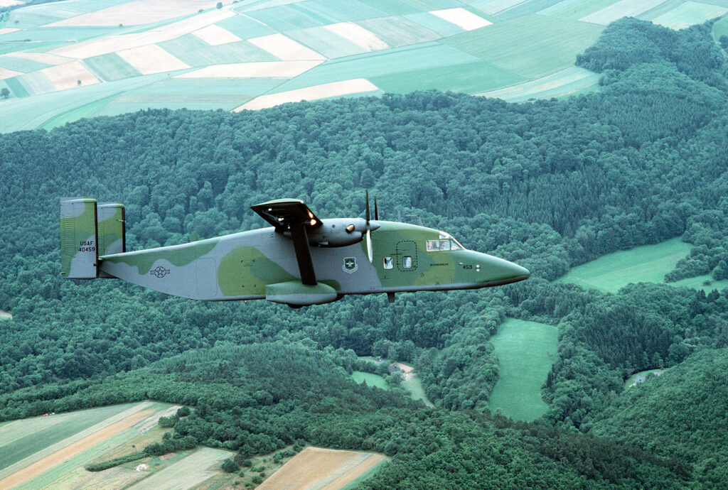 An air-to-air right side view of a 10th Military Airlift Squadron C-23 Sherpa aircraft. The Sherpa is flying over the German countryside en route to Hahn Air Base to deliver airplane parts.