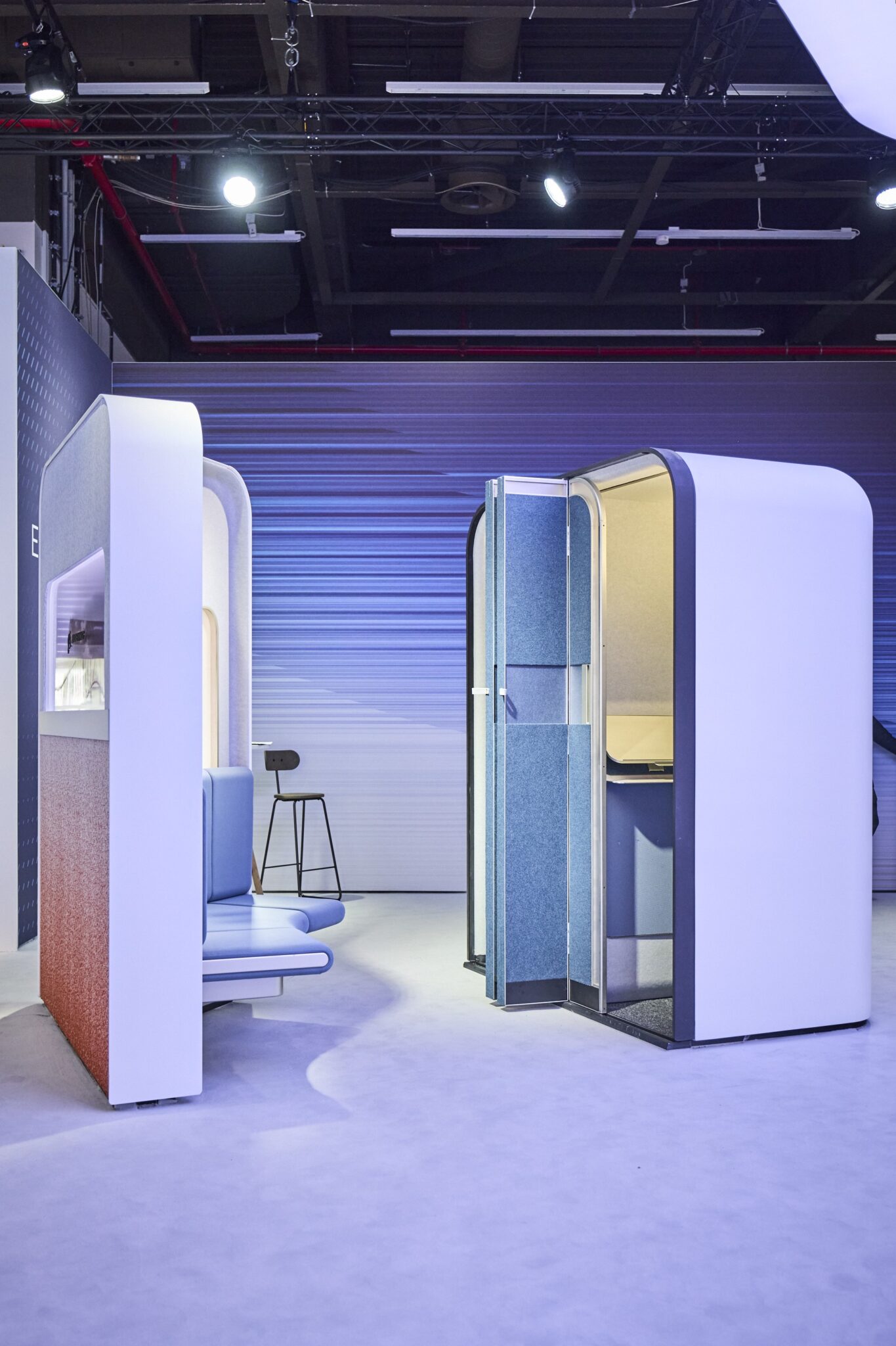 Side view of E-Lounge concept with private booths and a bench opposite of them.