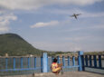 An ATR aircraft flying over Indonesia. A small child looks up.