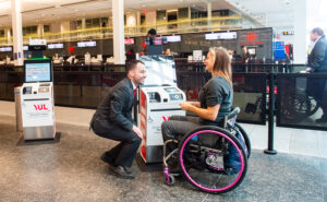 An Air Canada employee is assisting a passenger with a wheelchair at YUL
