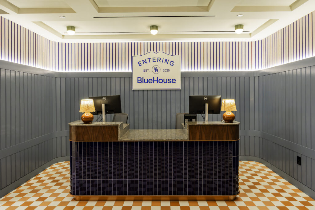Check-in desk features different accent lights and geometric + striped patterns