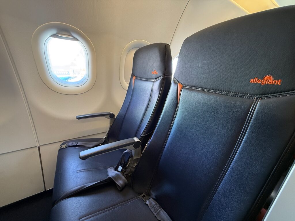 A close up of the armrest on the aircraft seat.