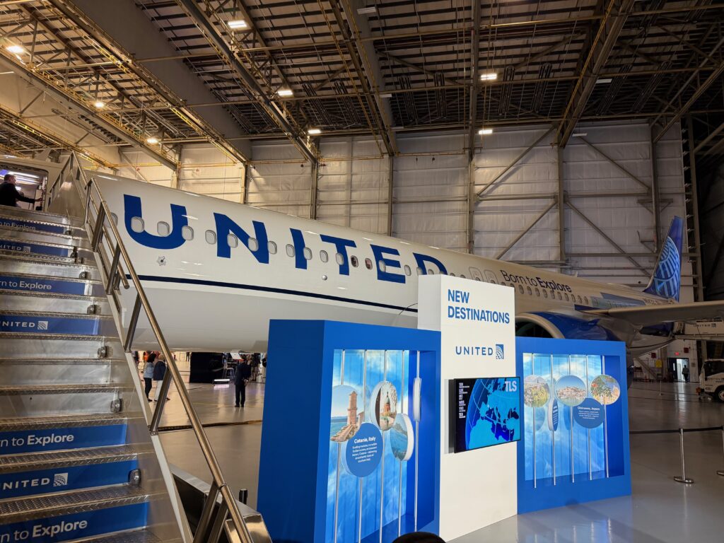 United A321XLR parked in the carrier's Newark hangar. A podium with the words "new destinations" is in front of the jet