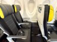 Seat duo on left side of A220. Seat are grey with yellow trim on the headrests.