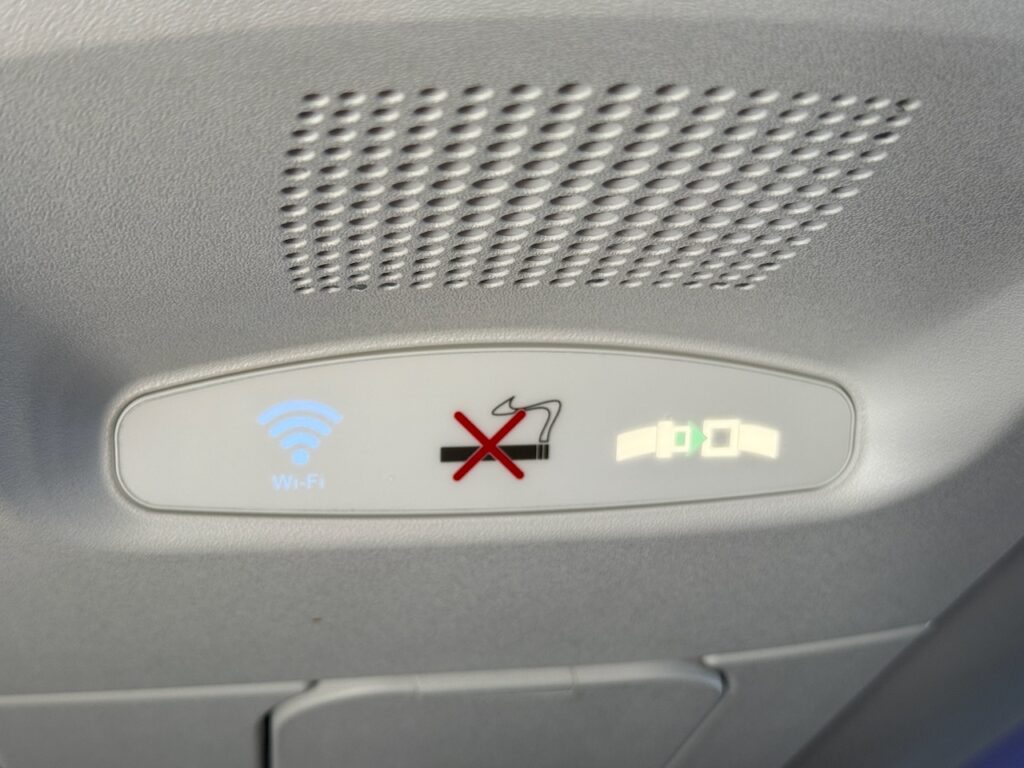 A close up of the seatbelt sign on the aircraft.