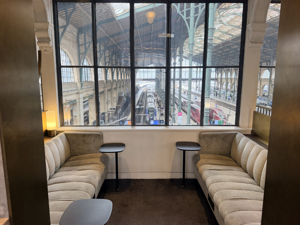 A seating nook is flanked by a grand window overlooking the station.