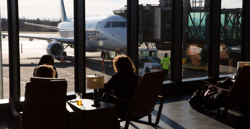Passengers enjoy views of the ramp in the Paine Field terminal with floor to ceiling windows
