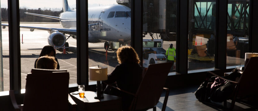 Passengers enjoy views of the ramp in the Paine Field terminal with floor to ceiling windows