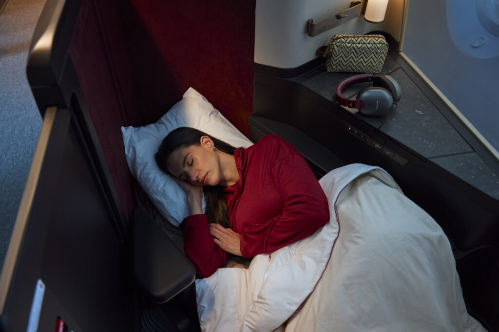 A woman enjoys the full-flat bed experience in her doored mini-suite on the Avianca 787
