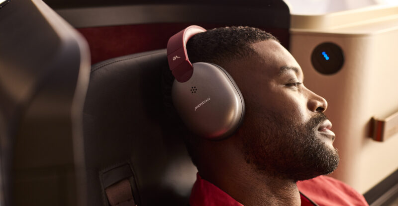 A male passenger enjoys the new INSIGNIA experience with noise-cancelling headphones on the 787