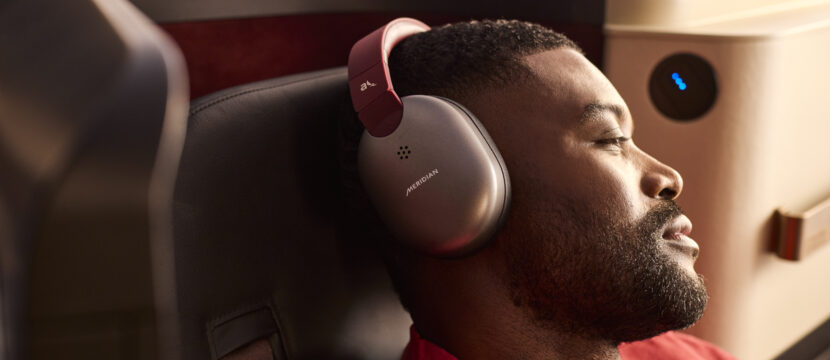 A male passenger enjoys the new INSIGNIA experience with noise-cancelling headphones on the 787