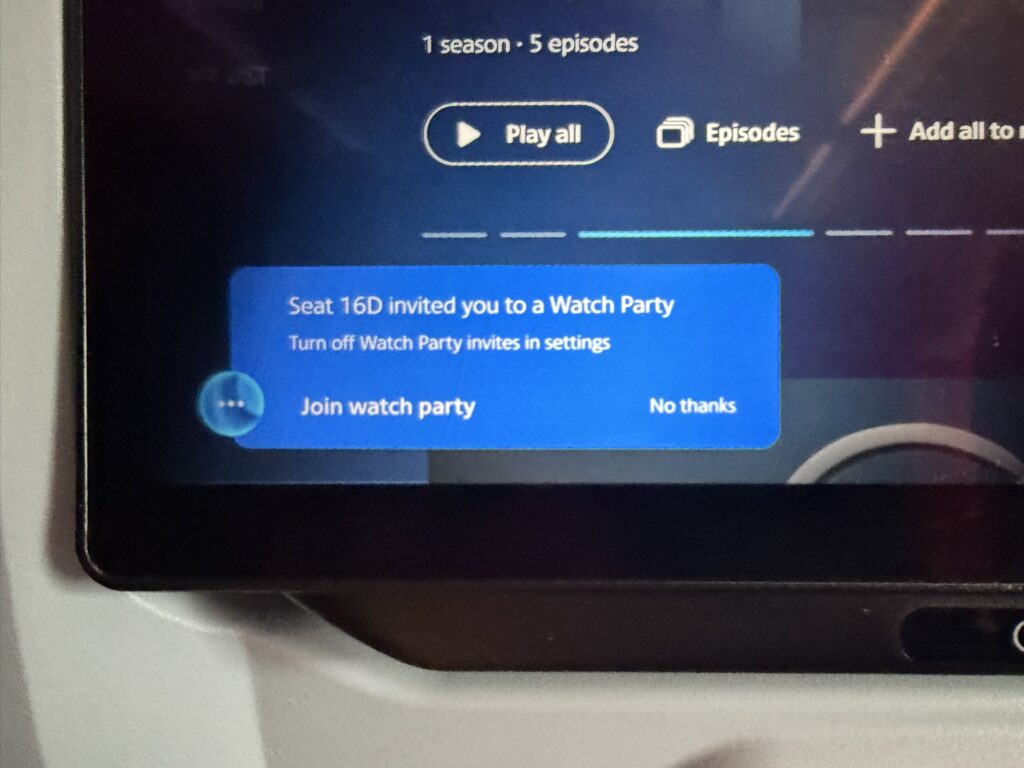 A blurb on the screen says Seat 16D is inviting the seat occupant to join their Watch Party
