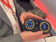 RAVE Aerospace's Ben Asmar holds up the new IFE and seat controller concept, which offers more accessible jog wheels as opposed to a touchscreen