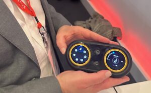 RAVE Aerospace's Ben Asmar holds up the new IFE and seat controller concept, which offers more accessible jog wheels as opposed to a touchscreen