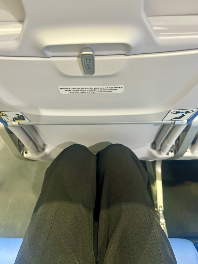 The tall journalist's knees have clearance even in this ZIM seat that's pitched at 28 inches