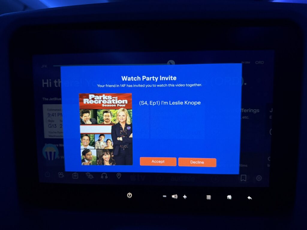 An invitation for a Watch Party is displayed on the JetBlue A220 IFE screen.
