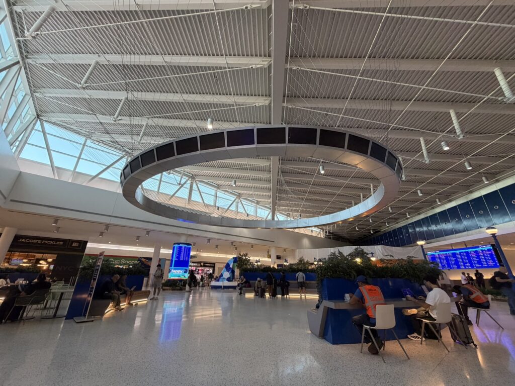 Inside the JFK airport T5 terminal with ceiling art and large displays