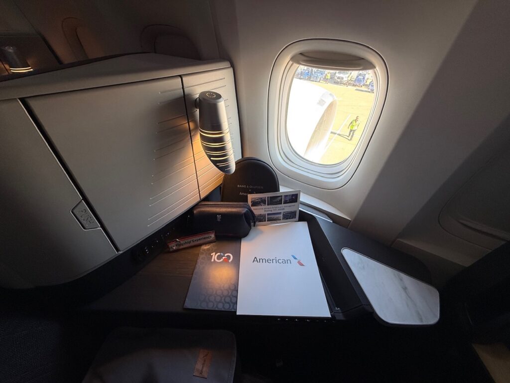 A side table and light fixture in a Flagship Suite aboard the AA 777-300ER