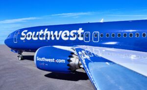 Southwest Airlines 737 MAX 8 with its bright blue and white livery is parked in the sunshine.