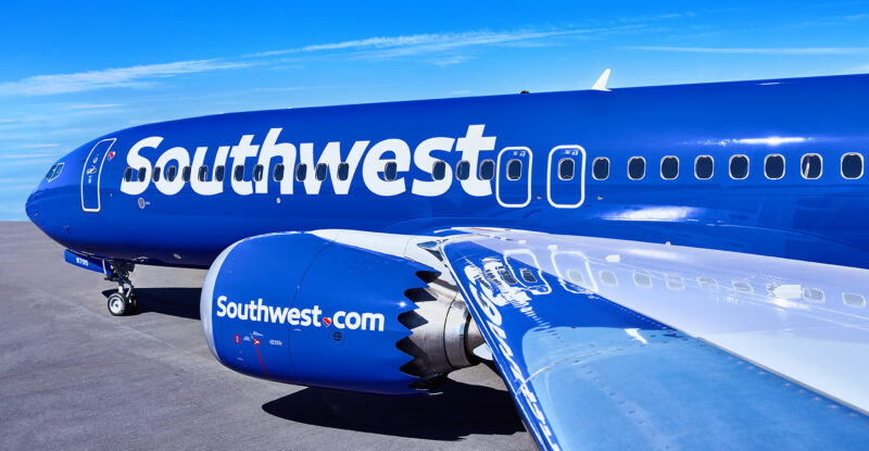 Southwest Airlines 737 MAX 8 with its bright blue and white livery is parked in the sunshine.