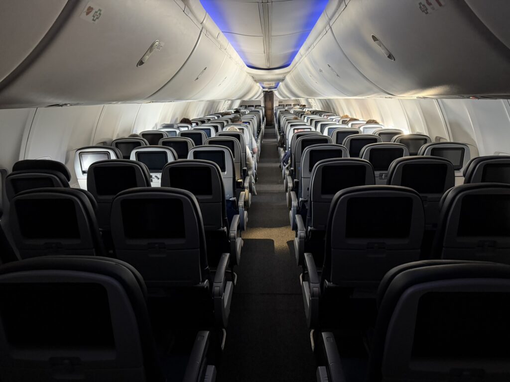 United Airlines Boeing 737-800 cabin with blue mood lighting and seatback IFE