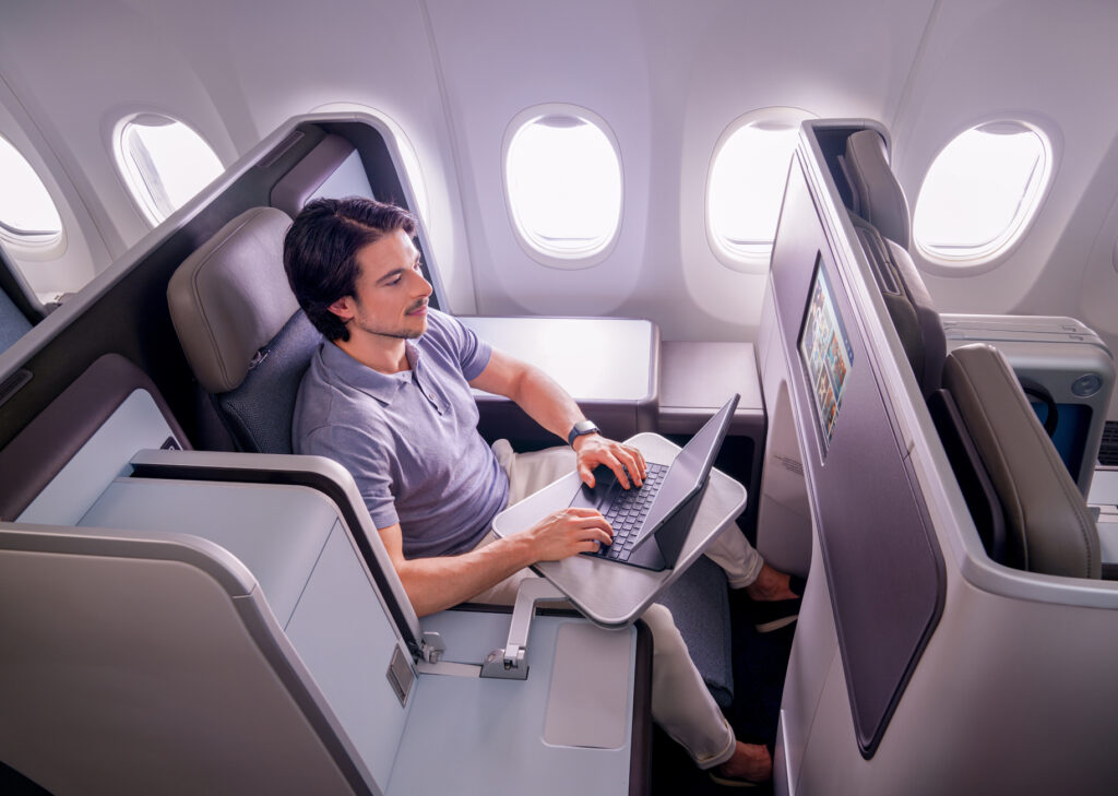 flydubai business class seat with a male passenger using his computer.