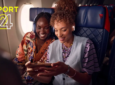 Two female passengers are watching Sport 24 in flight on their personal devices.