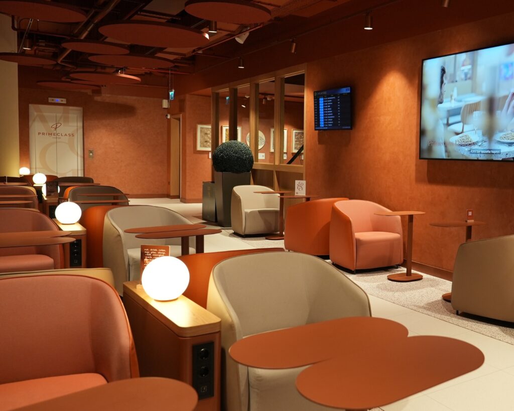 Primeclass lounge seating area with seats clad in alternating orange and beige material