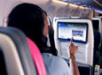 A passenger is using Astrova IFE screen by Panasonic Avionics
