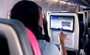 A passenger is using Astrova IFE screen by Panasonic Avionics