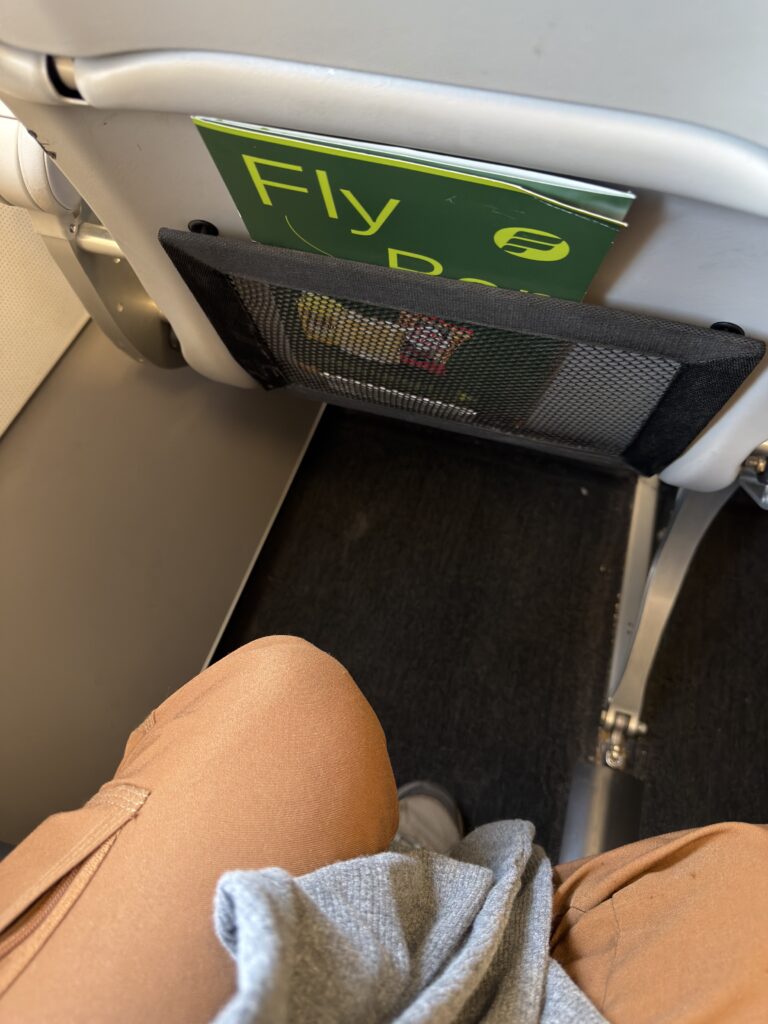 The author's knees are seen a decent distance away from the seat in front of them aboard the Frontier A321neo