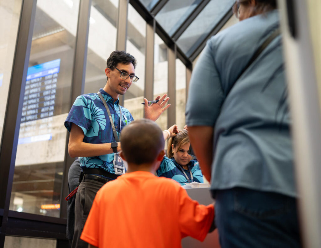 Hawaiian Airlines flight crew members explain the process to children.