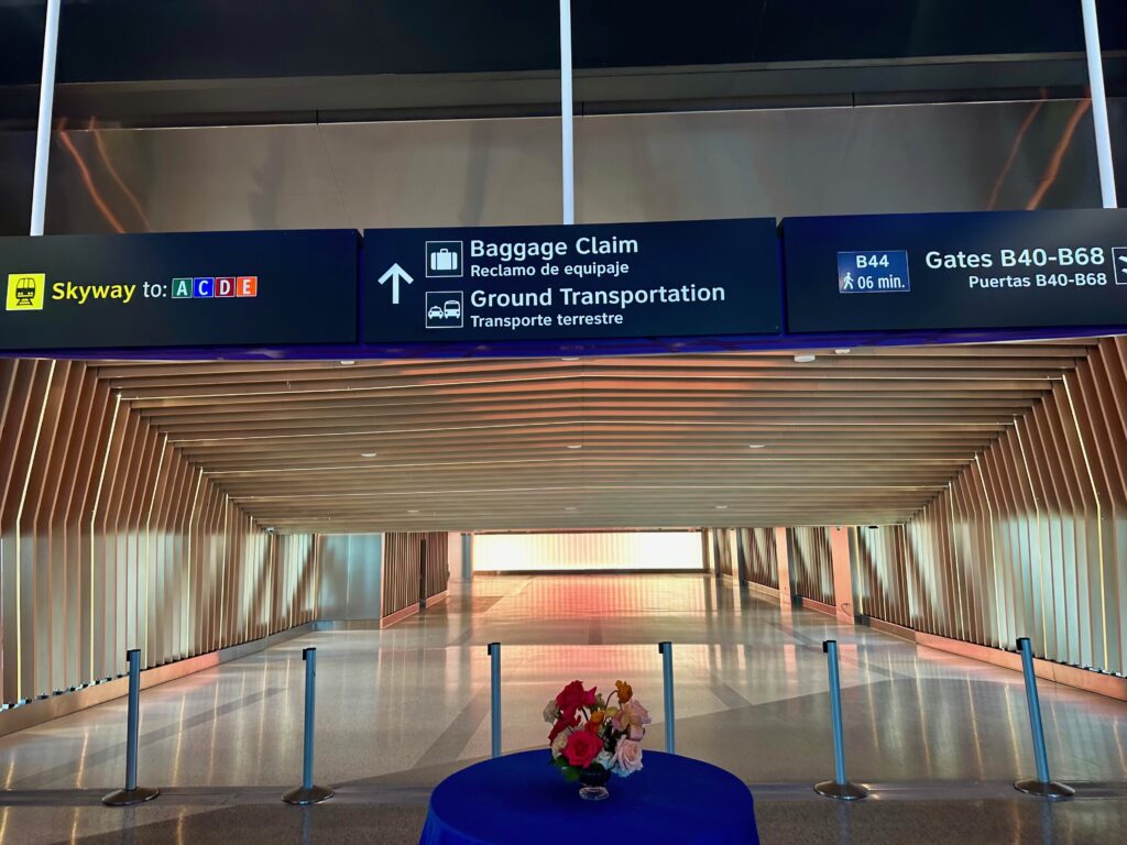 Signing to baggage claim, and a long, wide hall with various LEDs