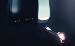 A passenger using their PED onboard the aircraft.