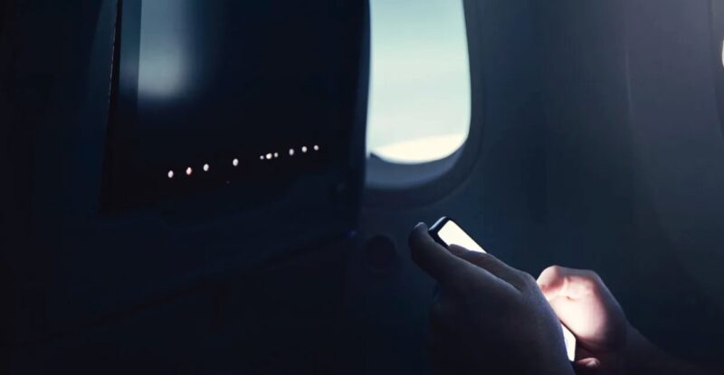 A passenger using their PED onboard the aircraft.